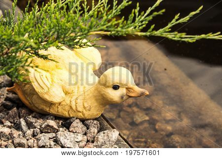 Ceramic duck near a pond in park