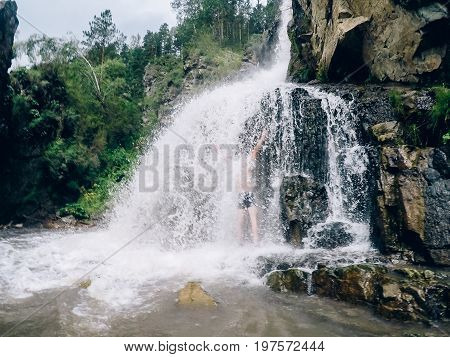 Man in Kamyshlinskiy vodopad waterfall summer, mountains Altai, Russia.