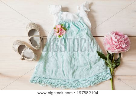 Girl's dress floral tiara and shiny shoes on a wooden background. Girl's apparel for party top view