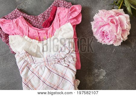 Stack Of Baby Girl Clothes In Pastel Color Range