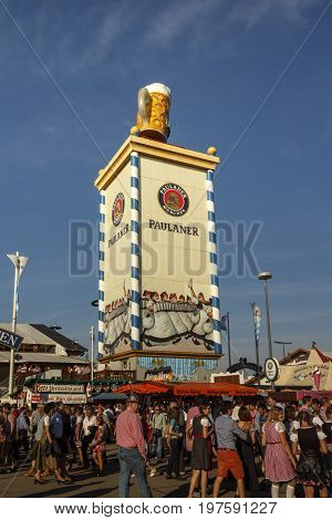 Munich, Germany - September 24, 2016: Roof of the Paulaner tower with the famous beer stein and unidentified people walking by