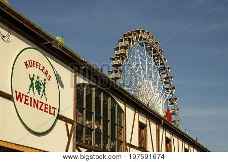 Munich, Germany - September 24, 2016: Ferris wheel on the fairground of the Octoberfest in Munich with the Weinzelt building in front