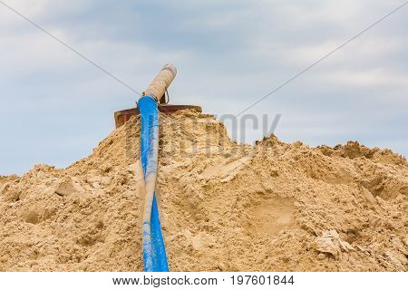Summer. Day. Quarry for the extraction of sand. In the frame the pipe is the exit from the dredger without the flow of water. Horizontal frame