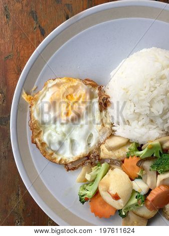 Mixed Fried Vegetable Tofu With Rice And Fried Egg In White Dish On Wooden Background. Vegetarian Fo
