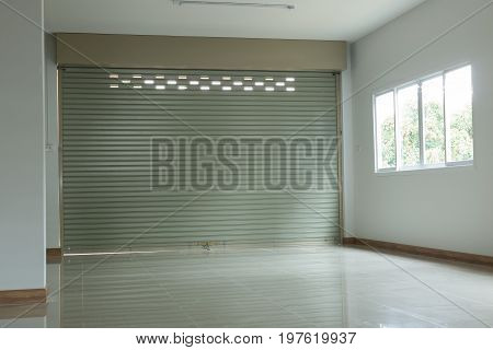 empty room in house residential building with aluminium roller shutter door and window glass sliding and white flooring tile