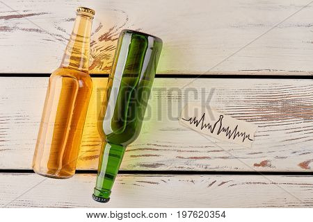 Botlles of beer, cardiac impulses image. Save your heart from alcohol harm.