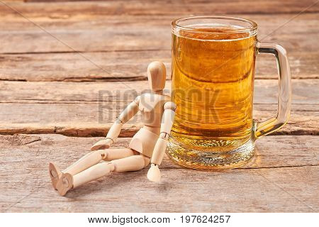 Human wooden dummy and beer. Beer addiction concept.