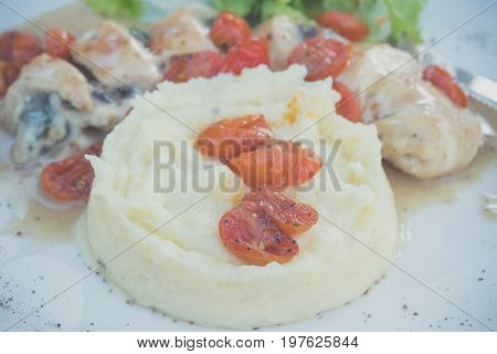 Sliced chicken with mashed potato and tomato cherry in italian sauce. Italian restaurant. delicious dinner.