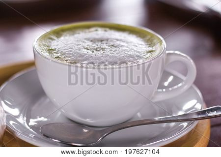 Hot matcha green tea latte glass with milk