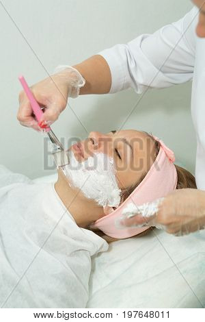 Beautiful young girl on facial cleansing procedure at a cosmetologist