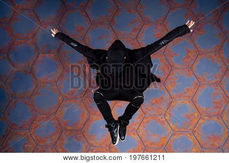 Young dancer jumping high near the urban wall.