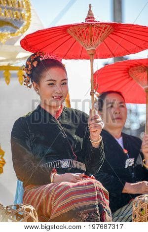 CHIANGMAI THAILAND - JANUARY 25 2015: Indigenous girl holding red paper umbrella in parade of 22nd Traditional Skirt Fabric and The Indigenous Product and Culture Festival in Mae Chaem Chiangmai Thailand