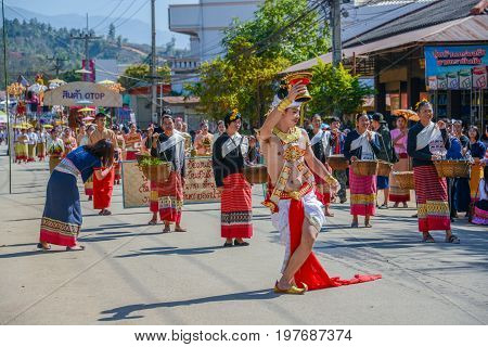 CHIANGMAI THAILAND - JANUARY 25 2015: Indigenous dancer man with traditional costume holding tray with pedestal of flower dancing in parade of 22nd Traditional Skirt Fabric and The Indigenous Product and Culture Festival in Mae Chaem Chiangmai Thailand