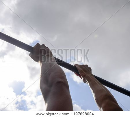 Hands On The Bar Close-up. The Man Pulls Himself Up On The Bar. Playing Sports In The Fresh Air. Hor
