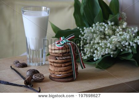 Milk, coockies and flowers on the table.