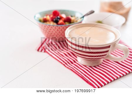 Healthy breakfast - cup of coffee, muesli and fresh berries on white wooden background, top view, health concept