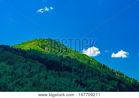 Blue sky white clouds green Altai Mountains at noon Ridder Kazakhstan