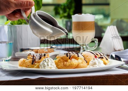 Eclairs with the dark hot chocolate and beze