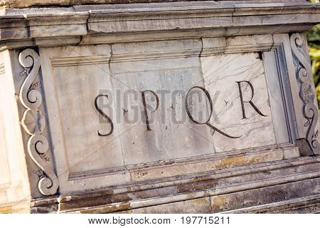 SPQR is Senatus Populusque Romanus, official emblem of modern-day Rome and classic symbol of Ancient Rome, phrase found all over city, imprinted beneath statue near Campidoglio and Colosseum.
