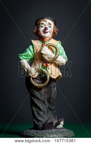 Closeup of a small figurine of a juggling clown with rings
