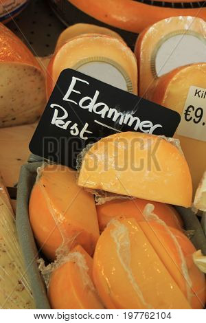 Traditional Dutch cheeses on display in a store (text on labels: price and product information in Dutch the famous Edammer cheese)