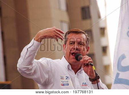 Quito, Ecuador - April 7, 2016: Closeup opposition leader Andres Paez talking with a microphone and surrounded by people and journalists during anti government protests in Shyris Avenue.