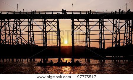 Silhouetted bridge at sunset in Sangkla Thailand .