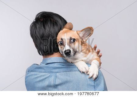 A Man Snuggling And Hugging His Dog, Close Friendship Loving In Studio Background