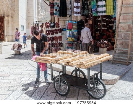 Jerusalem Israel July 14 2017 : Street vendor sells sweets near the entrance to the Suq Aftimos market in Muristan Street in the old city of Jerusalem Israel.
