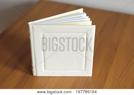 White square leather stitched opened book on the table