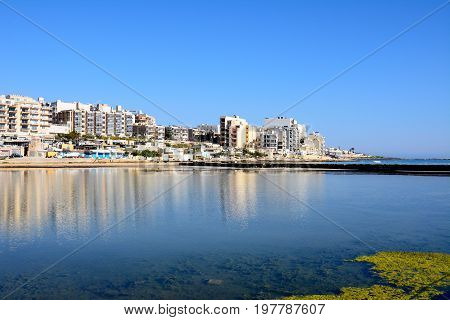 View of salt pans with buildings to the rear in Salina Bay Bugibba Malta Europe.