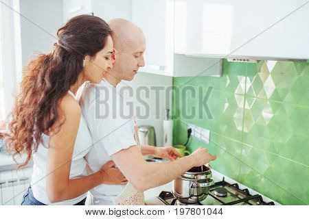 Happy young couple preparing on the stove.