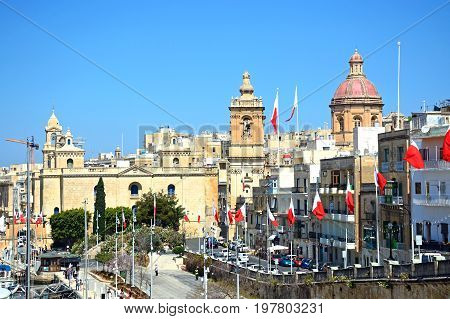 VITTORIOSA, MALTA - MARCH 31, 2017 - Elevated view along the waterfront buildings towards St Lawrence church Vittoriosa (Birgu) Malta Europe, March 31, 2017.