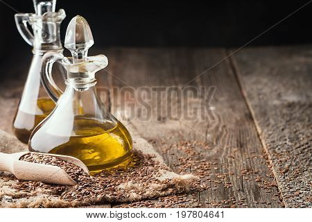 flax seeds and linseed oil in a glass jug on a wooden table, healthy diet with omega 3 fatty acids