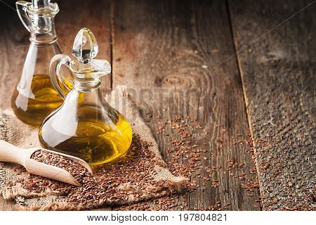 flax seeds and linseed oil in a glass jug on a wooden table, healthy diet with omega 3 fatty acids