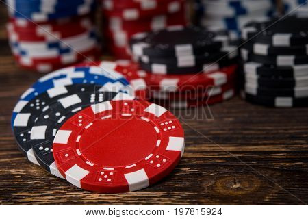 Poker chips on a wooden table scattered with a background