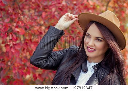 Young Beautiful Woman In A Hat And Jacket In Autumn Park. Warm Autumn. Autumn Portrait Of A Happy Gi