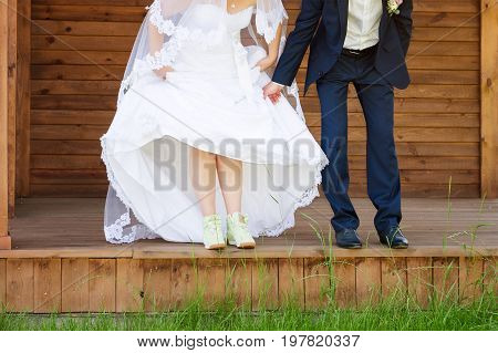 Funny beautiful wedding couple. Bride wearing green running shoes. Runaway Bride, close up