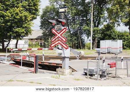 The railway crossing is closed. Lit red.