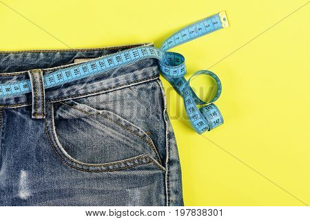 Healthy Lifestyle And Dieting Concept: Jeans With Measure Tape