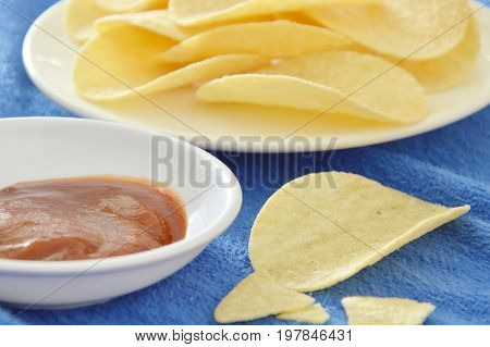 crispy and salt potato chips on dish dipping with tomato sauce