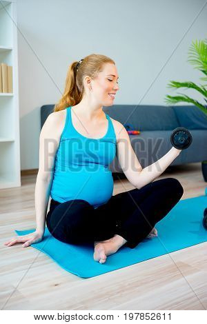 Pregnant woman doing yoga stretching at home