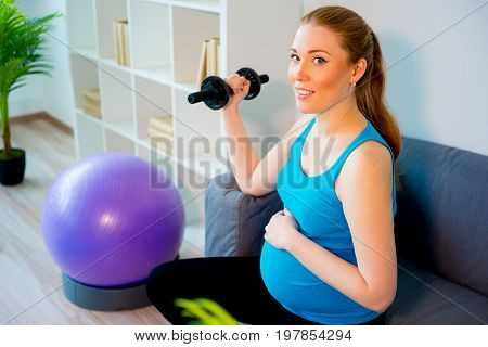 Pregnant woman doing pre-natal exercises at home
