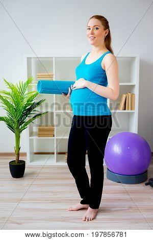 Pregnant woman doing pre-natal exercises at home