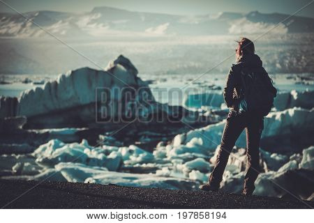 Woman explorer lookig at Jokulsarlon lagoon, Iceland.