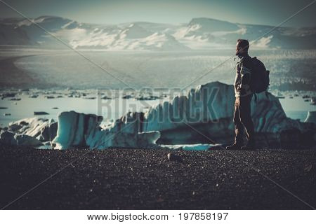Man explorer lookig at Jokulsarlon lagoon, Iceland.