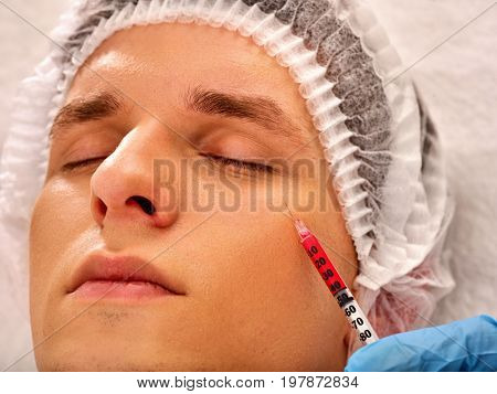 Filler injection for male forehead face. Plastic aesthetic facial surgery in beauty clinic. Man giving anti-aging injections for healthy complexion. Male face close-up.