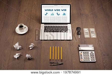 Laptop computer on wooden desk with office suplies