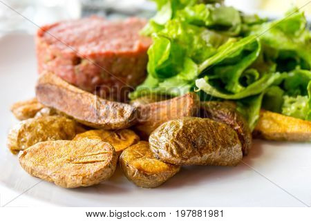 Raw beef classic steak tartare on white plate