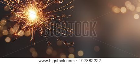 Festive background with sparkling wonder candle and tender golden bokeh for christmas